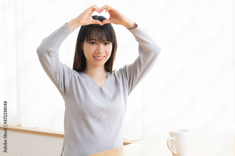 手でハートを作る若い女性