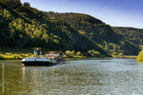 large river barge transporting goods on the Moselle River near Enkirch © makasana photo