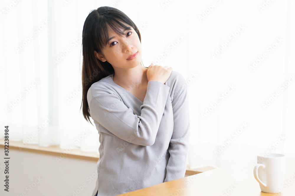肩に手を当てる若い女性 肩に手を当てる若い女性
