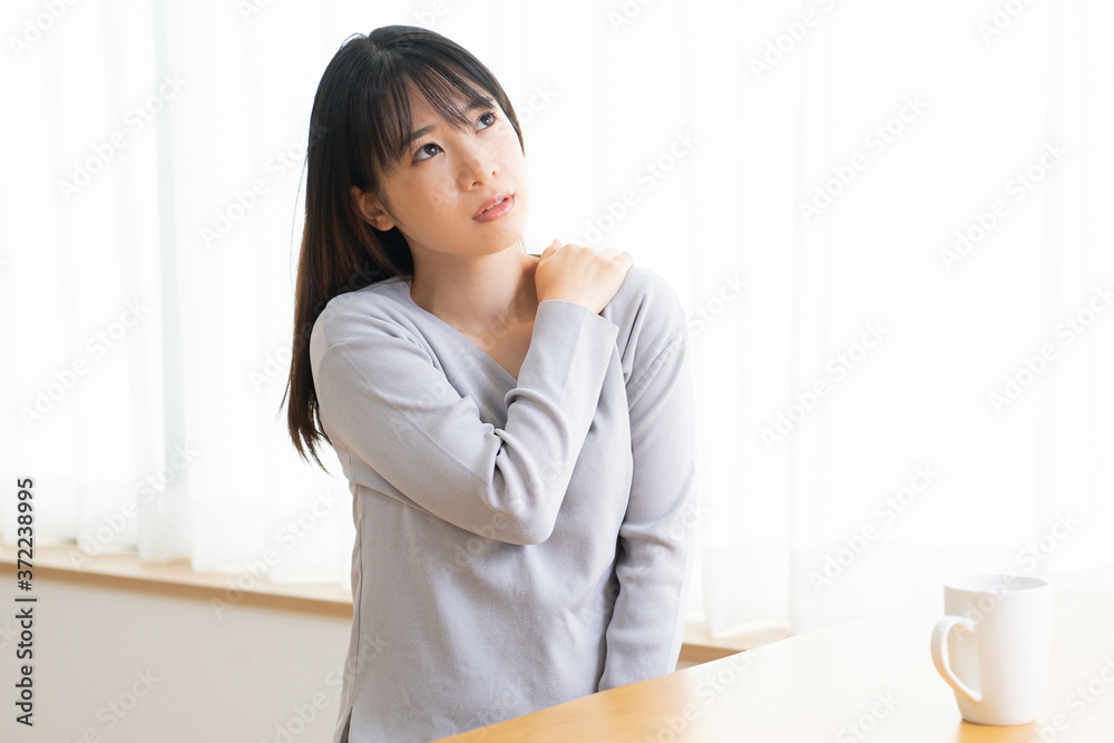 肩に手を当てる若い女性 肩に手を当てる若い女性