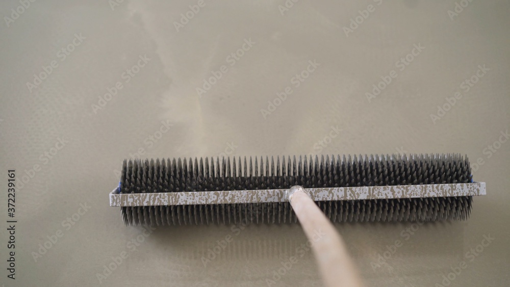 concrete floor. on the horizon. close-up. needle roller for removing air bubbles. have toning. then there will be painting. Needle roller for floor filling. concrete floor. on the horizon. close-up. needle roller for removing air bubbles. have toning. then there will be painting. Needle roller for floor filling.
