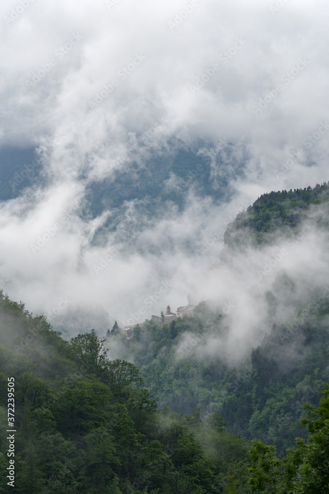 Fototapeta premium Mountains village covered in dense fog, Realdo, Province of Imperia, Liguria region, north western Italy