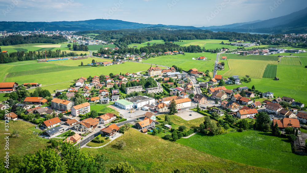 Aerial view of modern Epagny Gruyeres town and rural surroundings in La Gruyere Switzerland Aerial view of modern Epagny Gruyeres town and rural surroundings in La Gruyere Switzerland