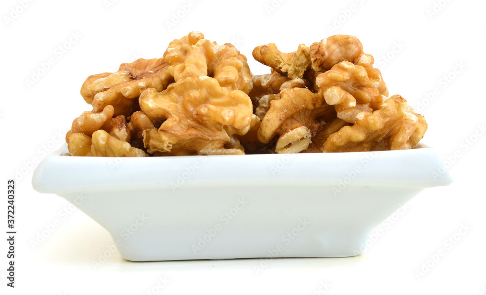 walnut on white in white bowl on white bakckground walnut on white in white bowl on white bakckground