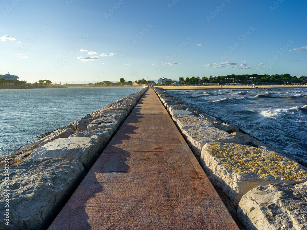 Seaside landscape with concrete jetty and blue sky