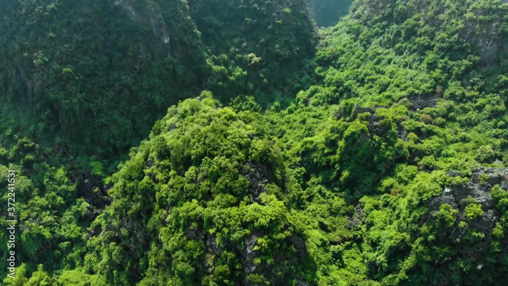 Aerial: North Vietnam karst landscape at sunset, drone view of Ninh Binh region, Trang An Tam Coc tourist destination, river flowing through unique limestone pinnacles and rice paddies Aerial: North Vietnam karst landscape at sunset, drone view of Ninh Binh region, Trang An Tam Coc tourist destination, river flowing through unique limestone pinnacles and rice paddies