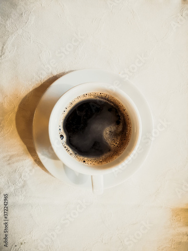 White cup of hot coffee on table