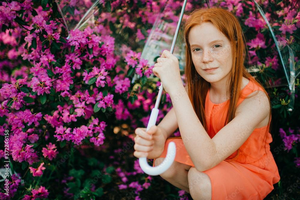 A cute girl in a summer dress enjoys plants in the botanical garden. A cute girl in a summer dress enjoys plants in the botanical garden.