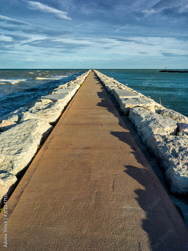 Seaside landscape with concrete jetty and blue sky