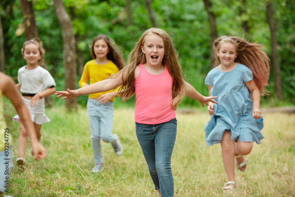 Memories. Kids, children running on green forest. Cheerful and happy boys and girs playing, laughting, running through green blooming meadow. Childhood and summertime, sincere emotions concept. Memories. Kids, children running on green forest. Cheerful and happy boys and girs playing, laughting, running through green blooming meadow. Childhood and summertime, sincere emotions concept.