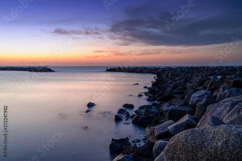 beautiful sunset on the coast of Rugen Island in Germany long exposure with a rock jetty