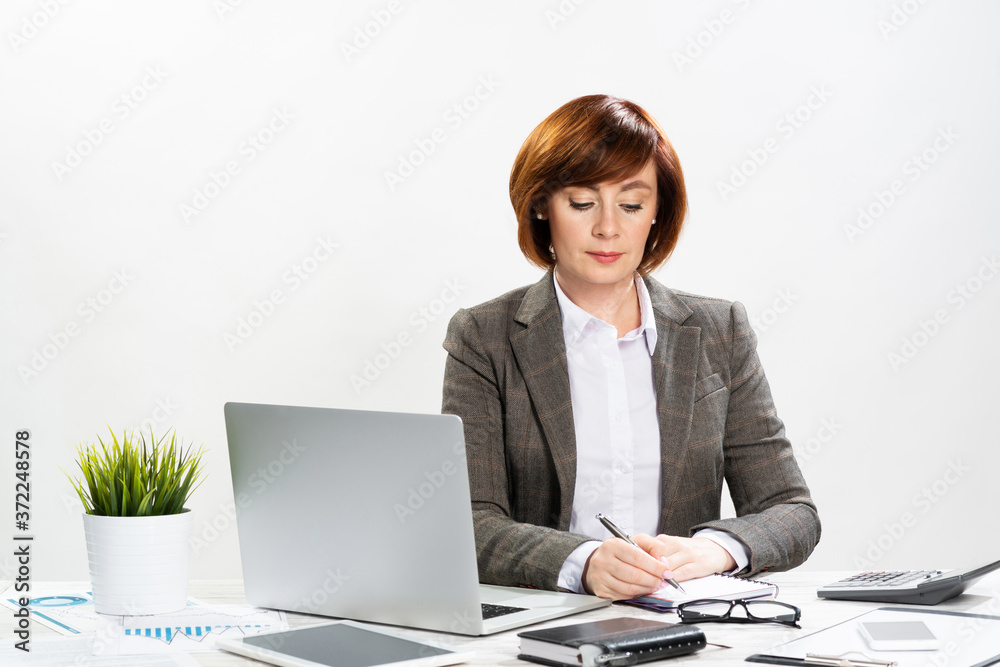 Attractive middle aged businesswoman writing Attractive middle aged businesswoman writing