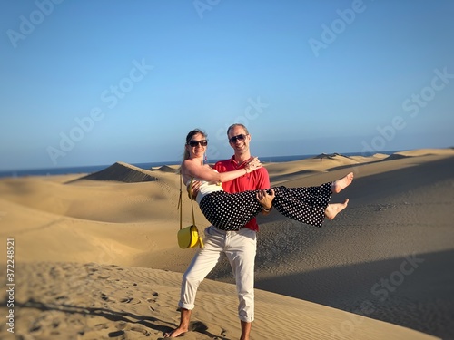 Jeune couple devant des dunes de sable désertique
