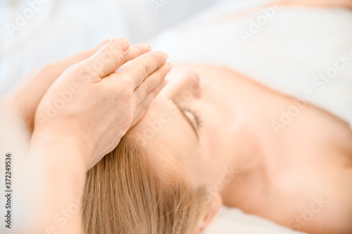 Beautiful woman receiving head and facial massage in spa salon. Concept of body health care and traditional thai massage relax