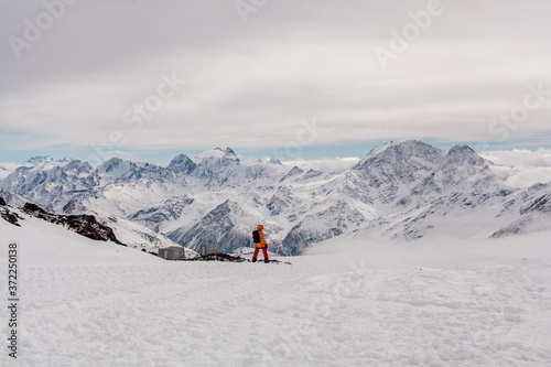 a snowboarder standing on a ski slope with a mountain view
