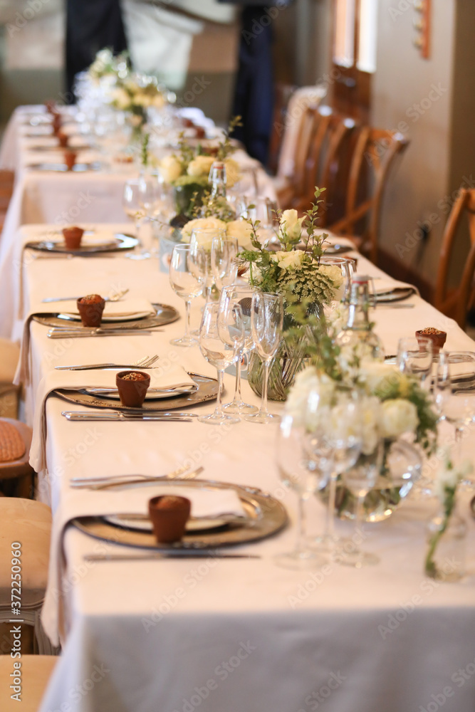 white flowers set up on tables for an event. white flowers set up on tables for an event.