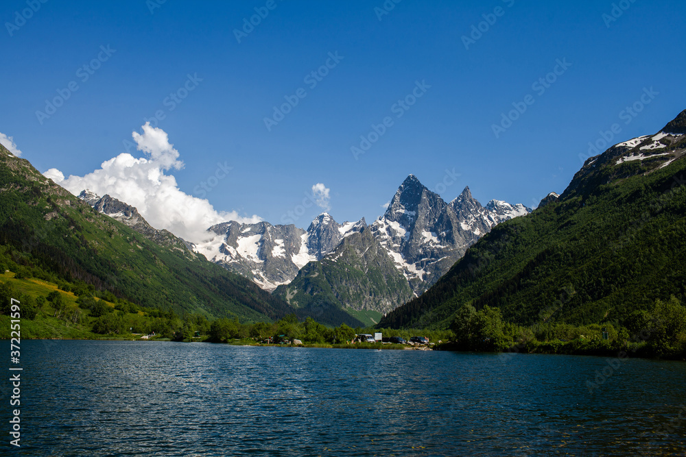 amazing deep mountain lake among rocks and peaks with snow.North Caucasus. Dombai