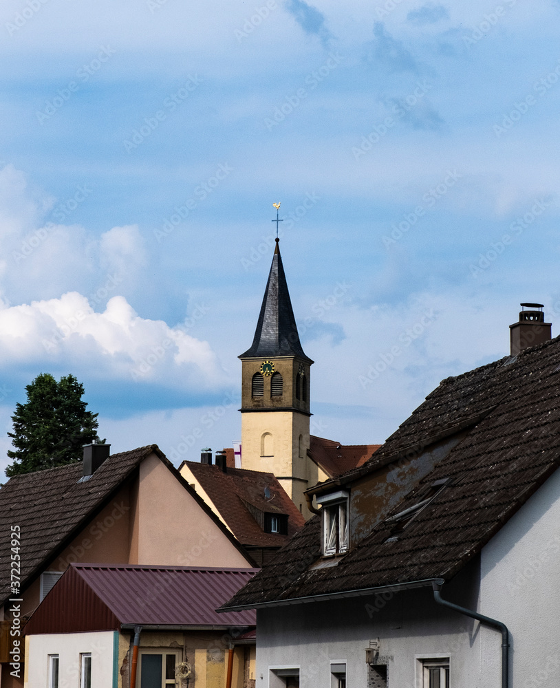 German village church and rooftops on a sunny summer day. Taken in Dentlein Am Forst, Germany.