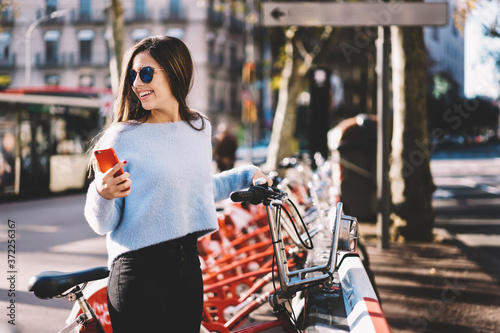 Foto Cheerful young trendy dressed female traveler planning to make sightseeing tour