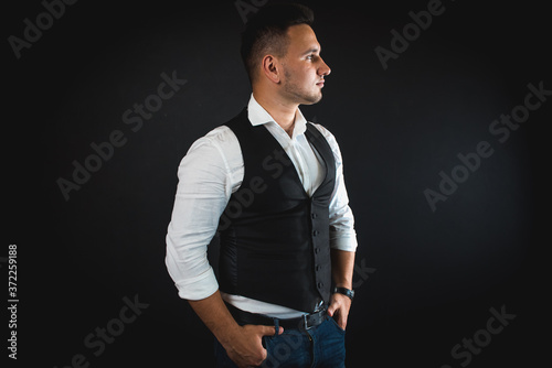 young attractive business man showing blank copy space over palm for customer to add item or text, looks happy and excited, isolated on dark background in white shirt