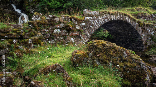 A packhorse bridge crossing a tributary below a waterfall on the south bank of the River Lyon. This is locally known as the Roman Bridge, though actually seems to date back to the 1600s or 1700s. photo