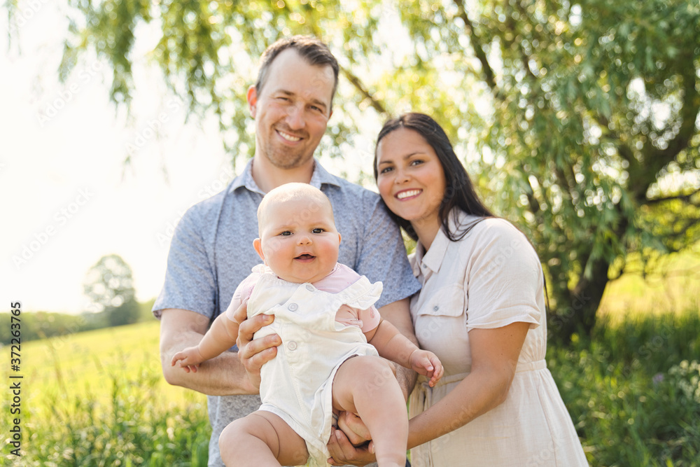 Happy and young family relaxing together in nature Happy and young family relaxing together in nature