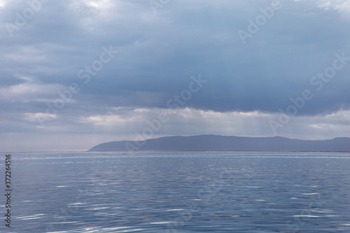 same tones of blue water and sky with the land in the distance