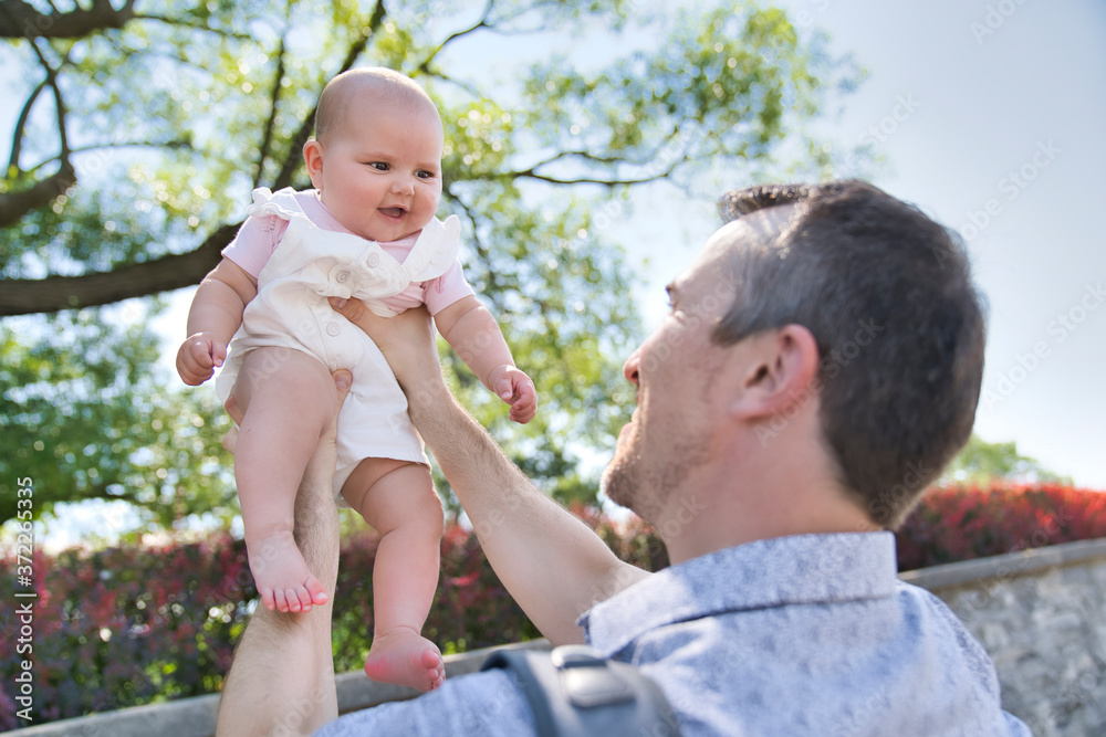 Father with baby girl standing outdoors by tree. Father with baby girl standing outdoors by tree.