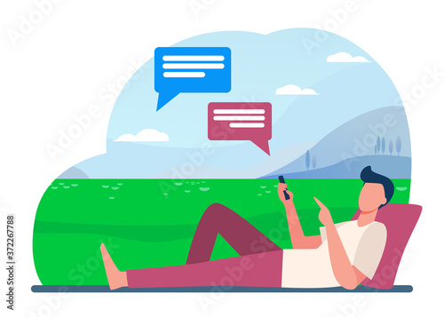 Young guy lying on meadow and chatting via phone. Smartphone, social media, park flat vector illustration. Communication and digital technology concept for banner, website design or landing web page