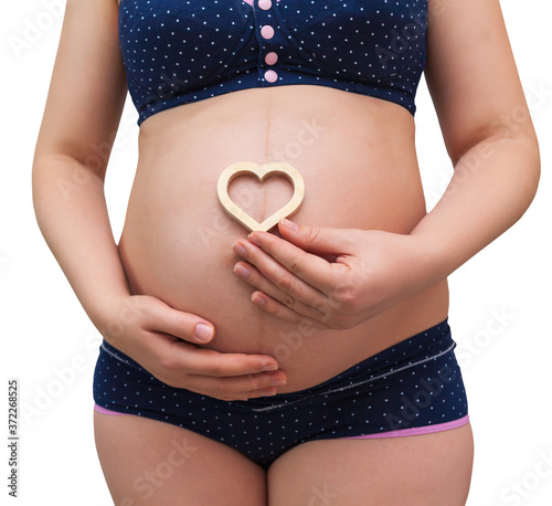 Wallpaper Mural A pregnant woman holds a heart symbol on the background of her belly Torontodigital.ca