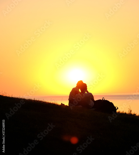 two young people sitting on the background of the sunset. Europe. 14.08.2020