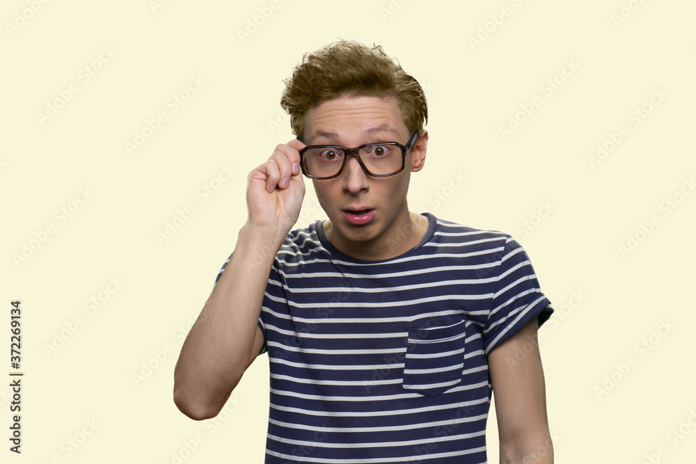 Surprised teen boy touching the spectacles. Handsome explorer boy looking shocked. Invention, insight, eureka concept. Surprised teen boy touching the spectacles. Handsome explorer boy looking shocked. Invention, insight, eureka concept.