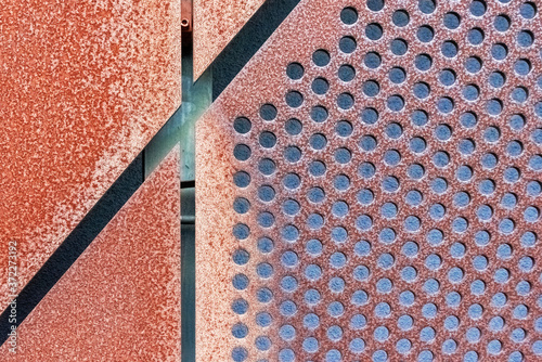 Abstract geometric background with rusty perforated metal cladding plates