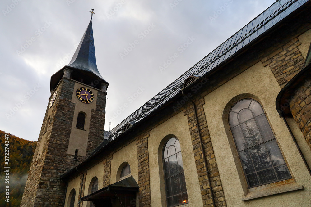 Fototapeta premium Zermatt, Switzerland-October 21, 2019:The Old chuch Building on Zermatt Bahnhofstrasse street in autumn and rainny day. ,Zermatt is a famous nature village in Switzerland.