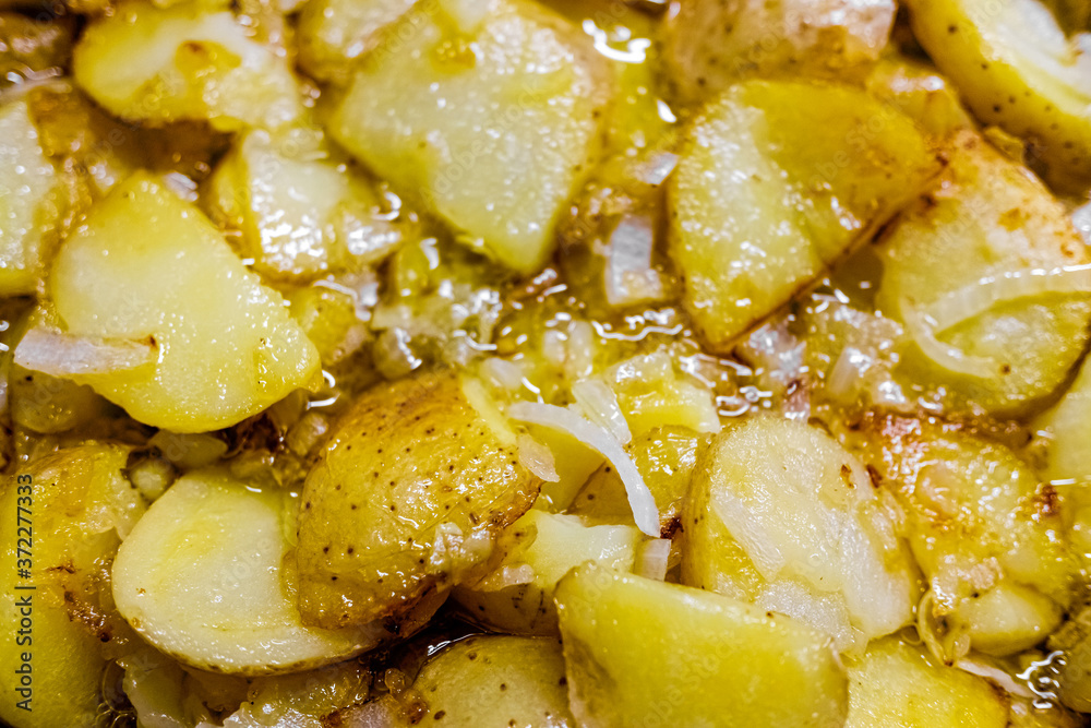 Typical Spanish dish made from potatoes and garlic, fried in a pan with olive oil, seen from above Typical Spanish dish made from potatoes and garlic, fried in a pan with olive oil, seen from above