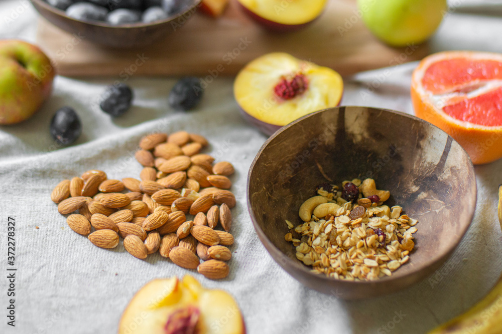 Making a vegan smoothie bowl with peach, banana, chia, granola and almonds in a coconut bowl. Vegan breakfast. Almond heart
Making a vegan smoothie bowl with peach, banana, chia, granola and almonds in a coconut bowl. Vegan breakfast. Almond heart