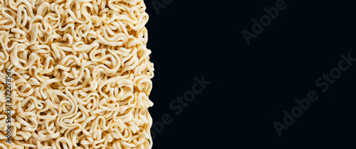 Background and texture of instant noodles on dark background. Panorama.