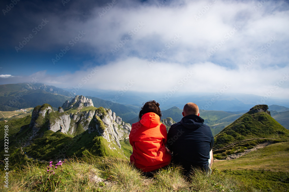 Fototapeta premium Young woman and man enjoying mountain view in Ciucas mountains, Romania.
