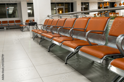 A row of empty seats at the airport. Close up. The diagonal composition. Concept. Topic of flight cancellations during the coronavirus pandemic. Rows of chairs for those waiting at the airport. © Алексей Закиров
