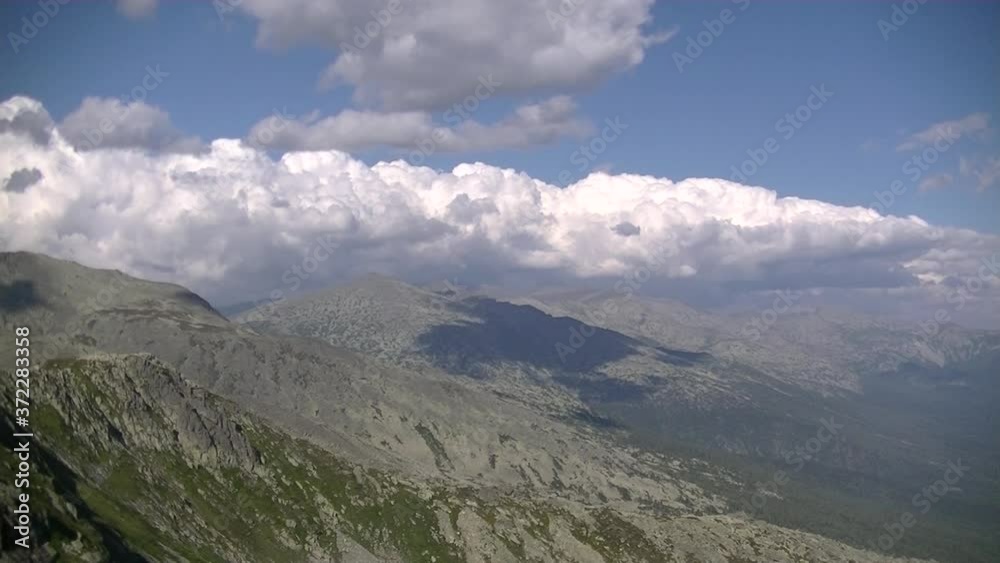 Cumulus and rain clouds over the tops of high mountains