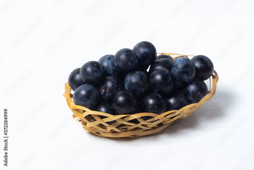 Plum in a wicker basket. Photo on a white background. Summer harvest Plum in a wicker basket. Photo on a white background. Summer harvest