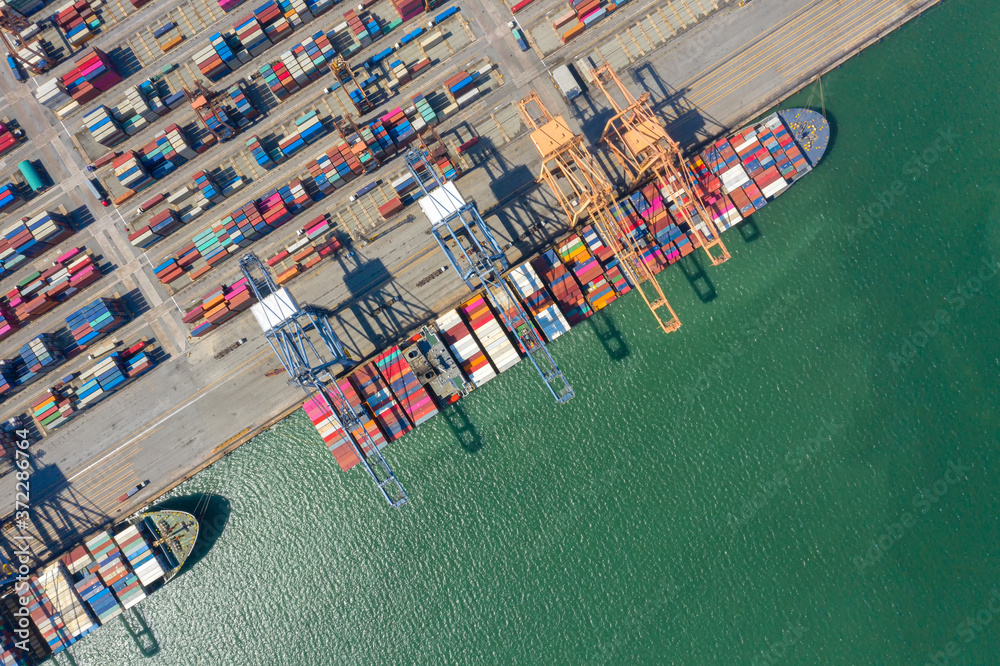 Obraz premium Container , container ship in export and import business and logistics. Shipping cargo to harbor by crane. Water transport International. Aerial view and top view.