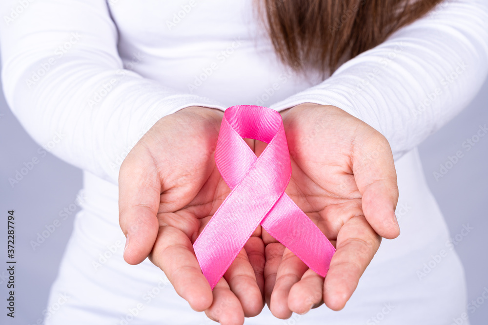 Woman hands holding pink breast cancer awareness ribbon. Medical, healthcare for advertising concept. Woman hands holding pink breast cancer awareness ribbon. Medical, healthcare for advertising concept.