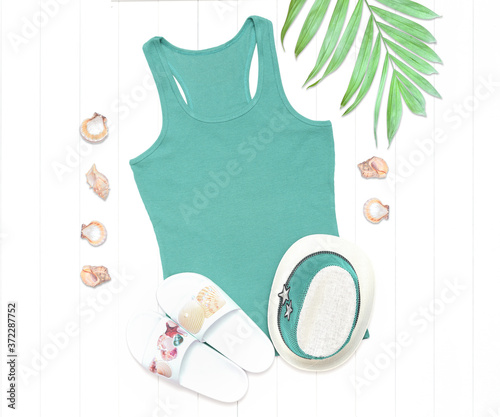 Mint tank top and palm leaves on a white wooden background photo