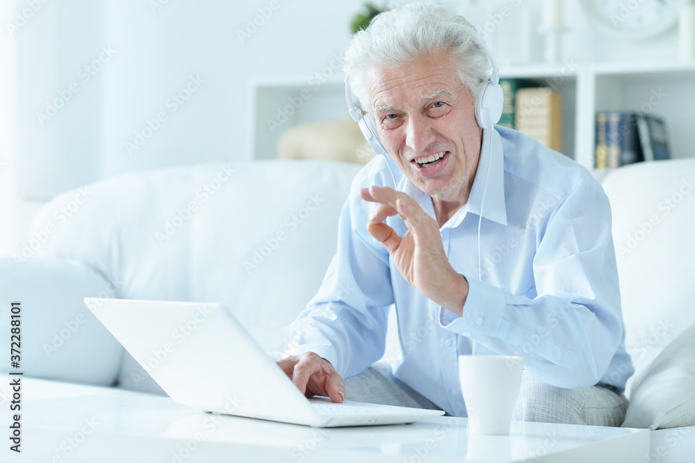 Portrait of senior man using laptop at home Portrait of senior man using laptop at home