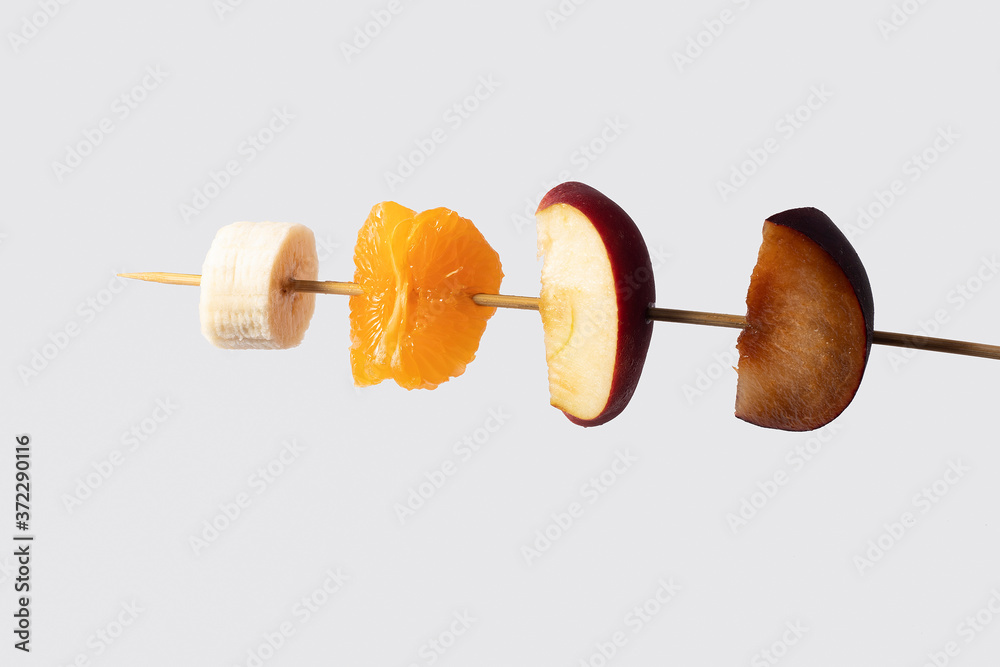 Seasonal fruit skewers over white background Seasonal fruit skewers over white background