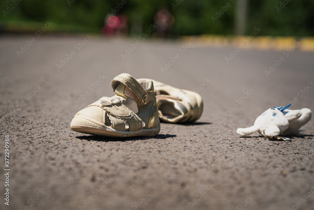 children's shoes on the road after dangerous traffic incident