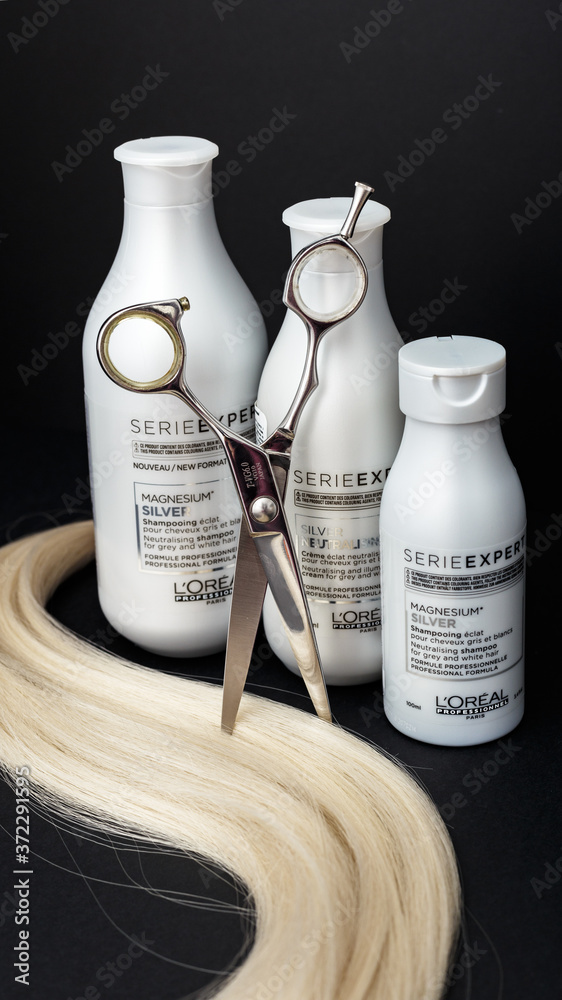 L'oreal professionnel Paris Serie Expert Silver hair professional products.Loreal  shampoo cream mask for grey white hair. Professional hairdresser scissors  and lock of blonde hair on black background Stock 写真 | Adobe Stock