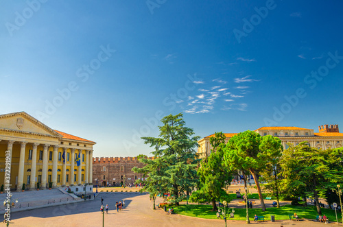 Piazza Bra square in Verona city historical centre with Palazzo Barbieri town hall building, Palazzo della Gran Guardia and park garden with green cedar and pine trees, Veneto Region, Northern Italy photo