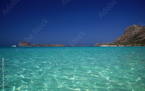 Amazing idyllic view of shiny turquoise sea water, of rocky coast, horizon, bright blue sky. Paradise holidays on ocean